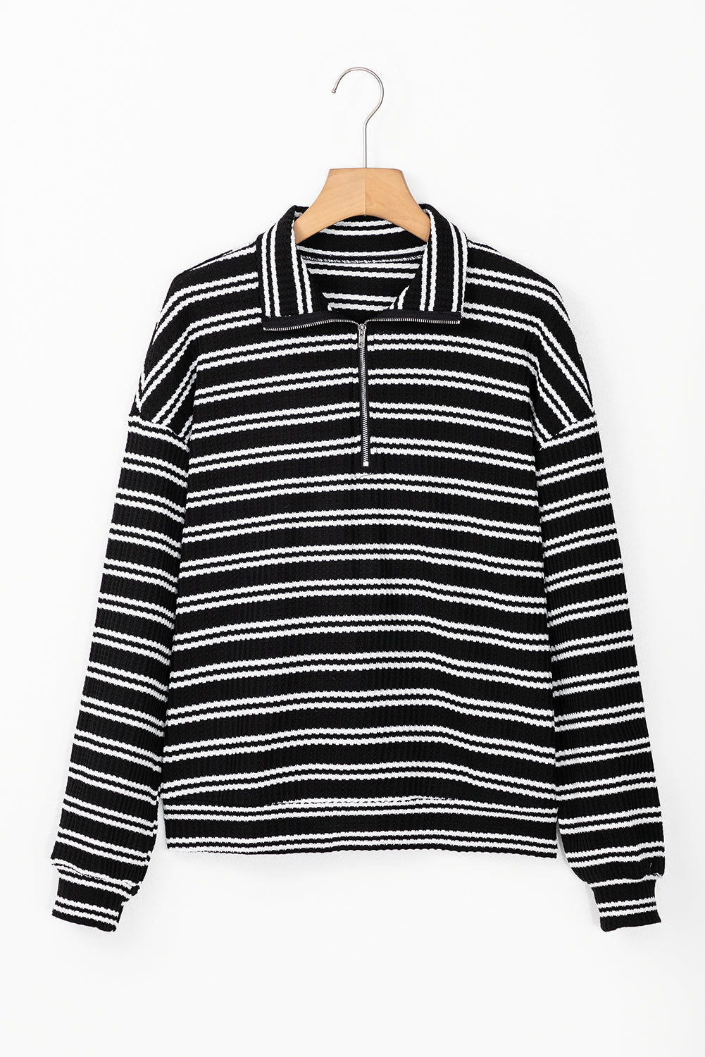 Top de manga larga con cuello y cremallera de un cuarto, con textura y rayas negras.
