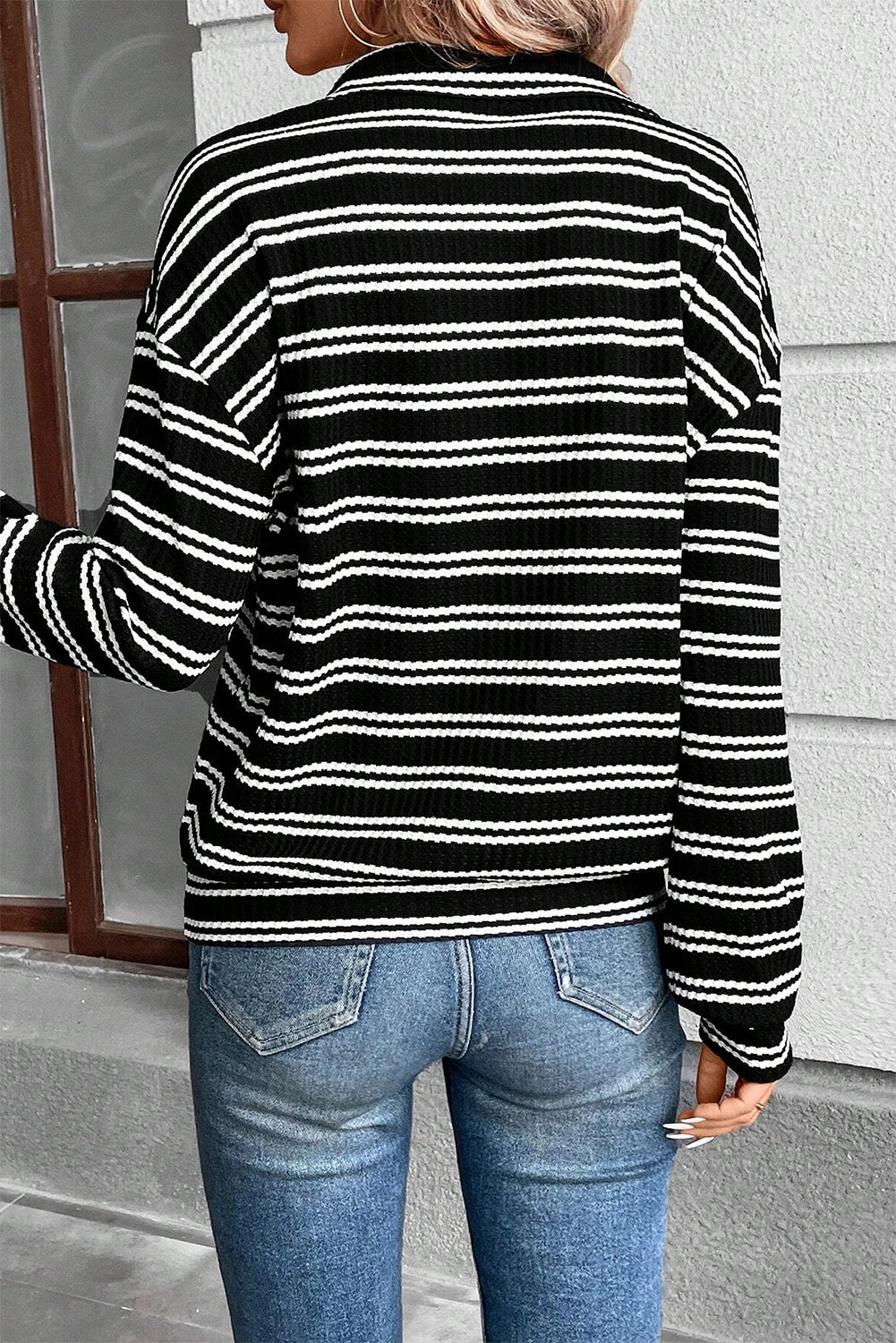 Top de manga larga con cuello y cremallera de un cuarto, con textura y rayas negras.