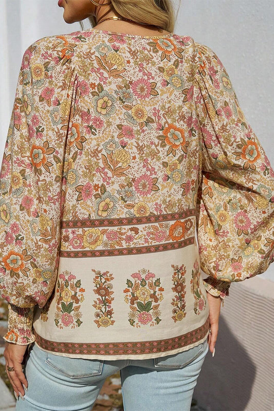 Blusa amarilla con estampado floral, cuello anudado y mangas farol