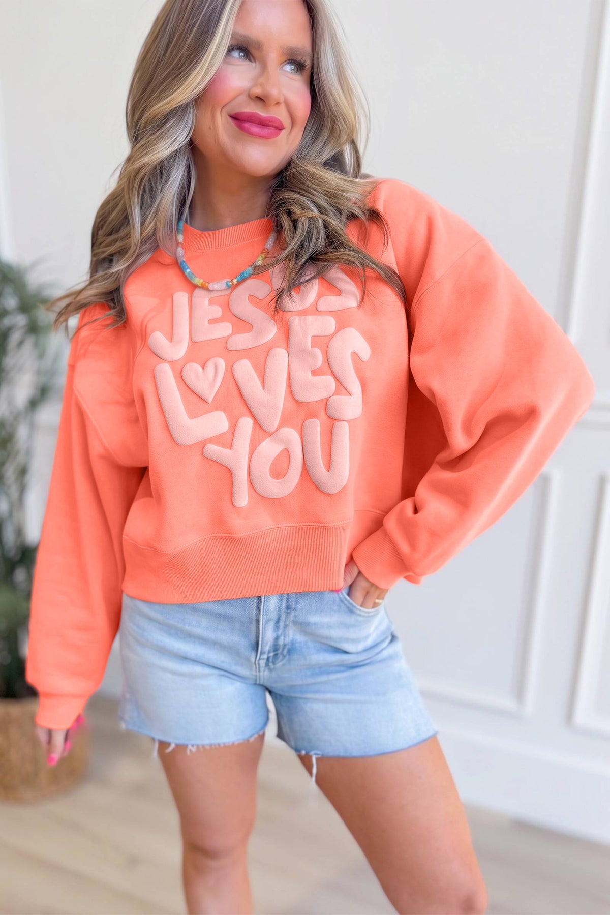 Sudadera con gráfico de letras en relieve "Jesus Loves You" (Jesús te ama) en tonos naranja y pomelo