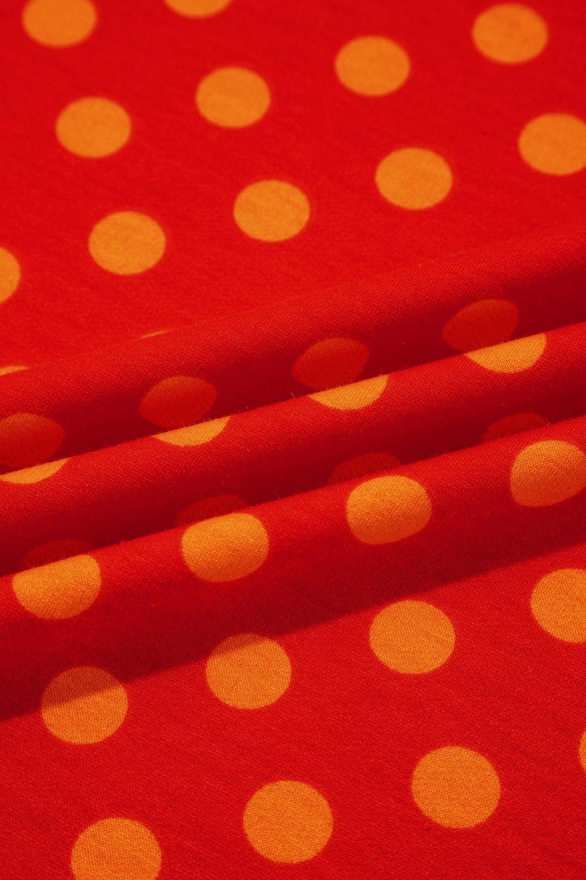 Top de cuello redondo con mangas tres cuartos, estampado de lunares marrones y ribete en contraste.