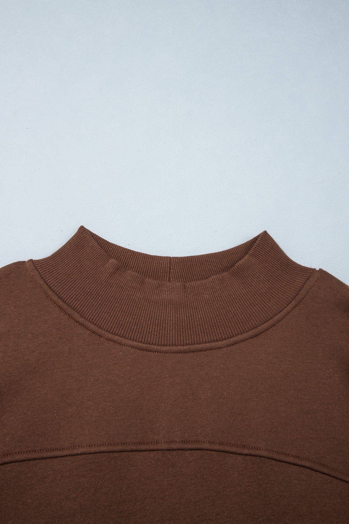 Sudadera tipo túnica de color liso, corte oversize, cuello alto y bajo con aberturas, en color café