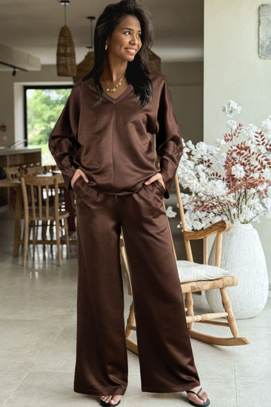 Conjunto de 2 piezas: blusa holgada de manga larga con cuello en V y detalle trenzado, y pantalón de tiro alto con cordón, en color marrón oscuro.