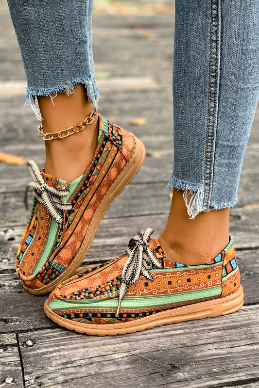 Mocasines cómodos color mostaza con estampado artístico de estilo étnico y detalle de cordones.