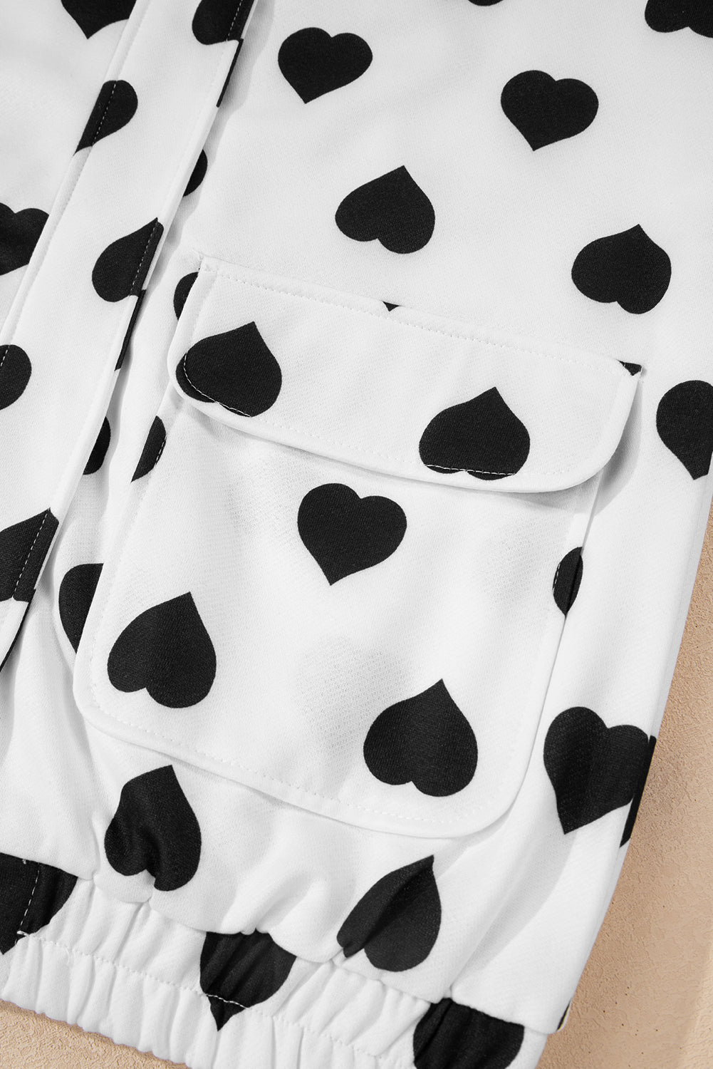 Chaqueta blanca con cremallera, cuello, estampado de corazones y bolsillos de doble solapa