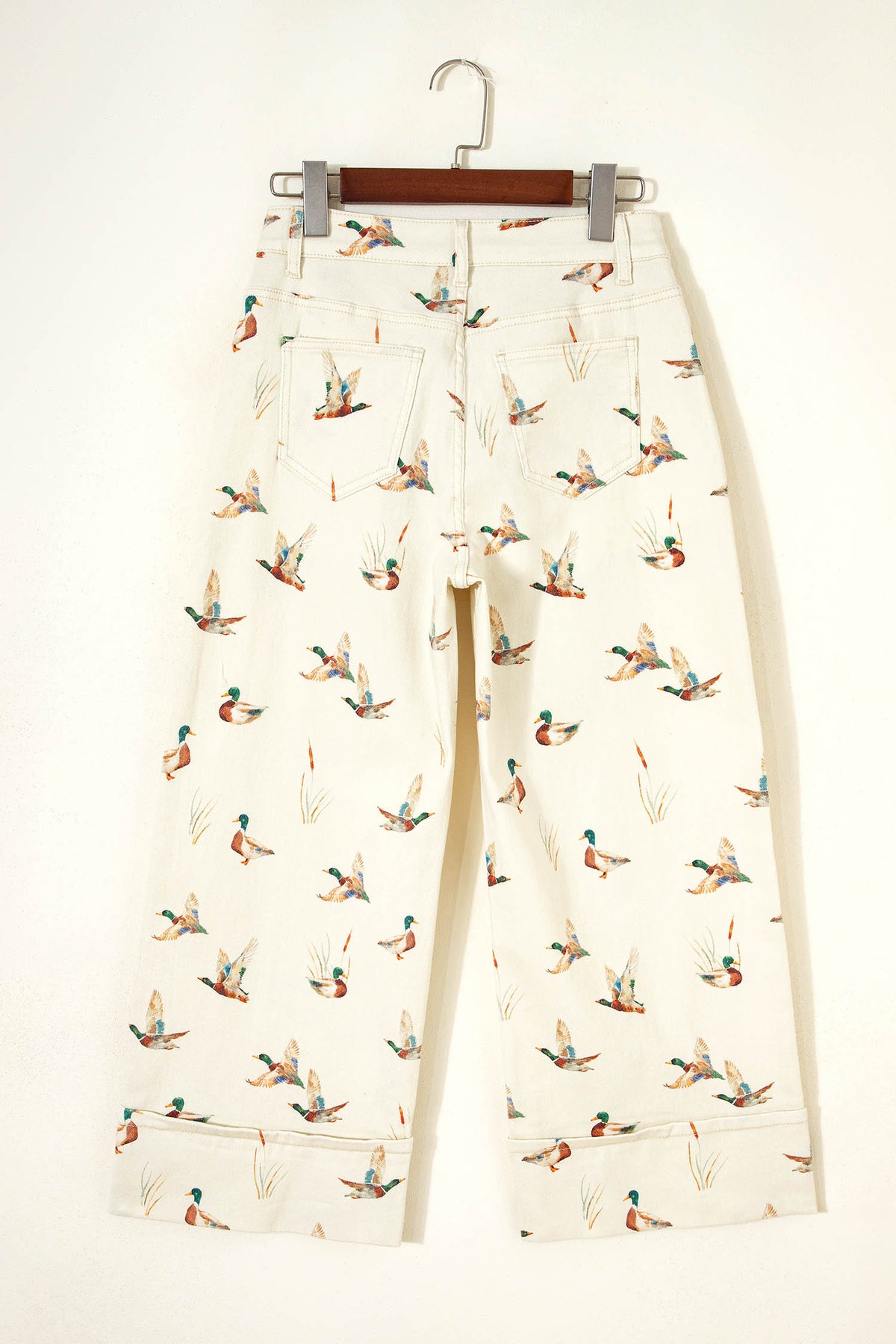 Vaqueros beige elegantes con estampado de patos y bajo con puños