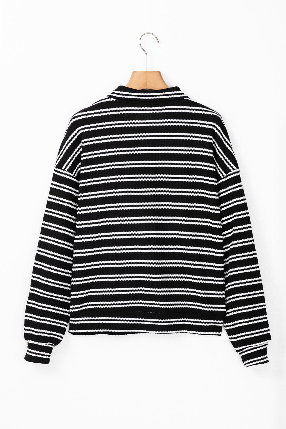 Top de manga larga con cuello y cremallera de un cuarto, con textura y rayas negras.