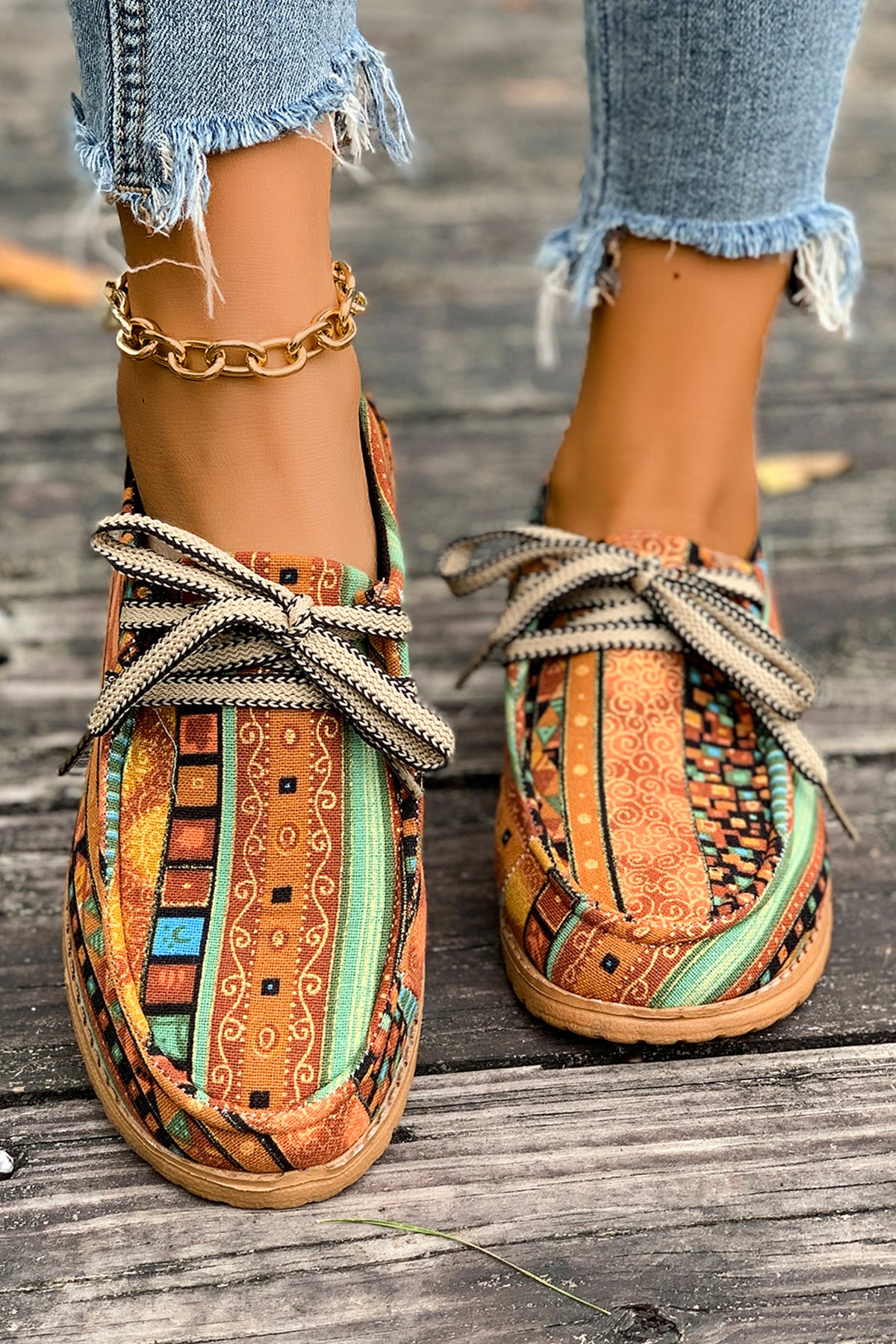 Mocasines cómodos color mostaza con estampado artístico de estilo étnico y detalle de cordones.