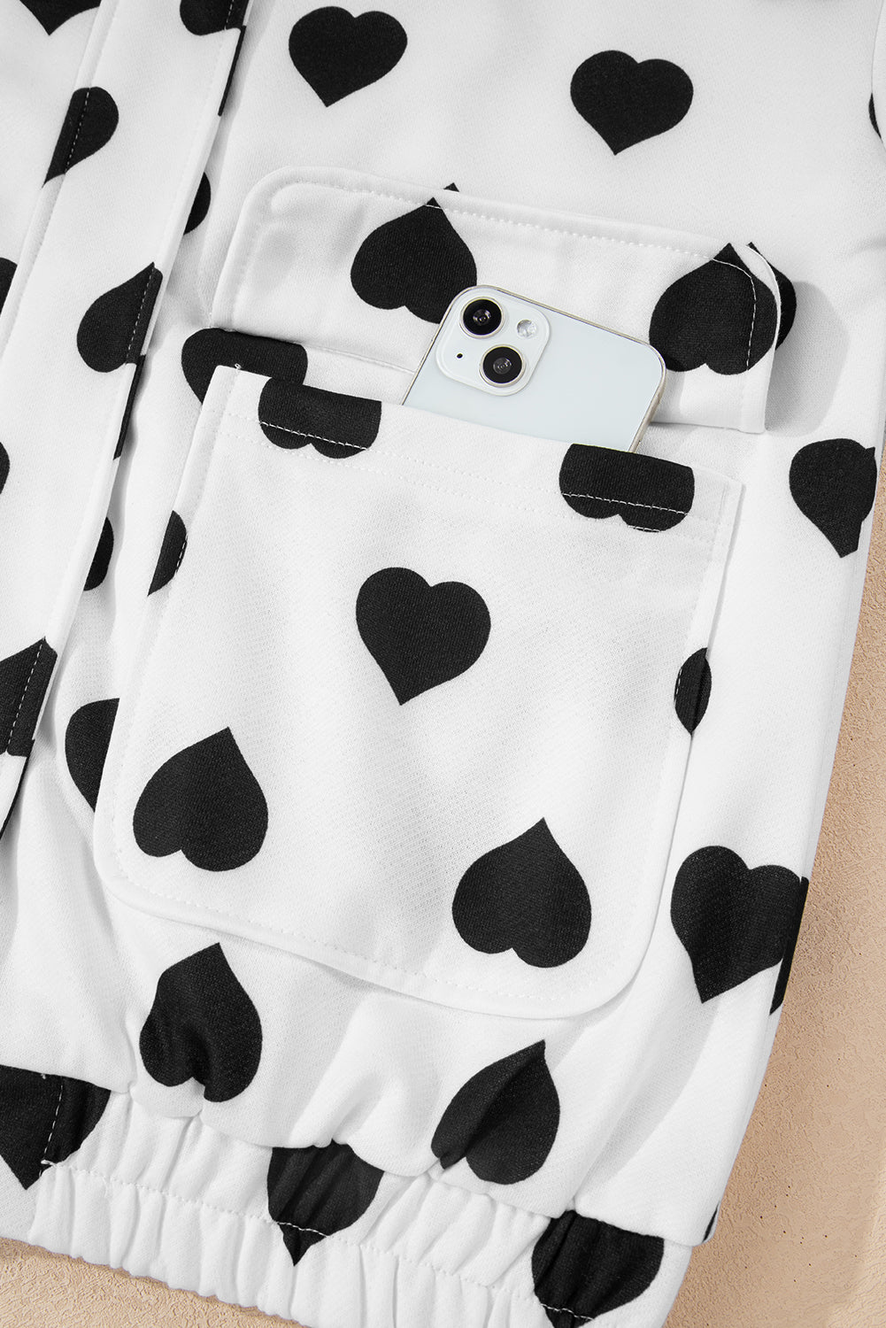 Chaqueta blanca con cremallera, cuello, estampado de corazones y bolsillos de doble solapa