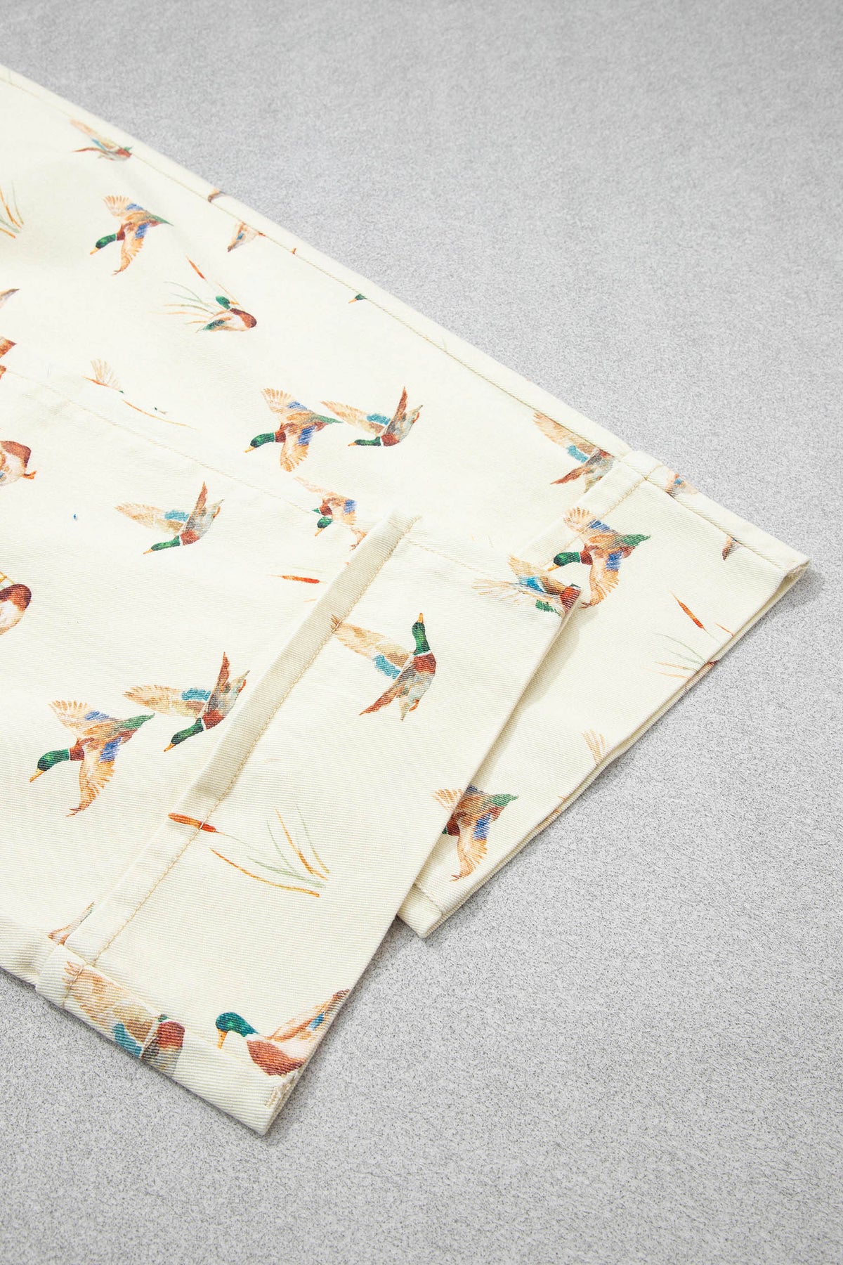 Vaqueros beige elegantes con estampado de patos y bajo con puños