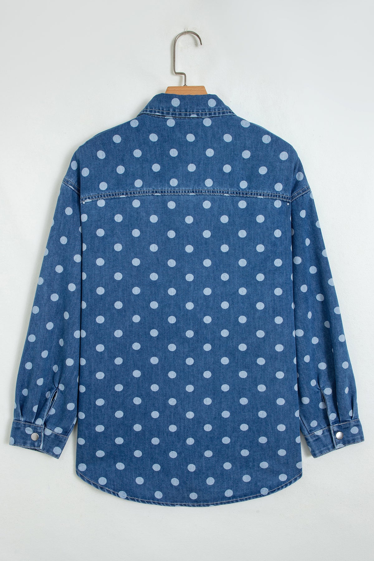 Chaqueta tipo túnica de mezclilla, corte recto, con cuello, manga larga y estampado de lunares azules.