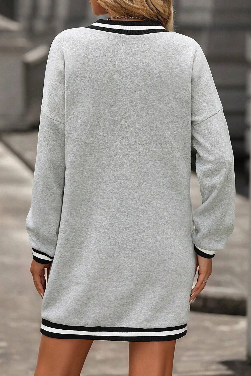 Vestido tipo camiseta de estilo preppy, manga larga y cuello en V, en gris claro con ribetes a rayas.