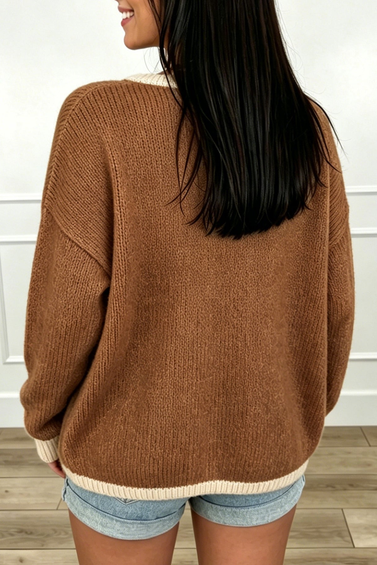 Cárdigan tipo suéter holgado color castaño con cuello en V, cierre frontal de lazada y ribetes en contraste.