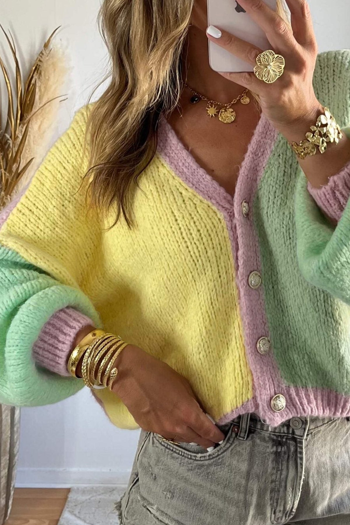 Cárdigan de punto amarillo con cuello en V, hombros caídos, diseño de paneles y lavado estándar.