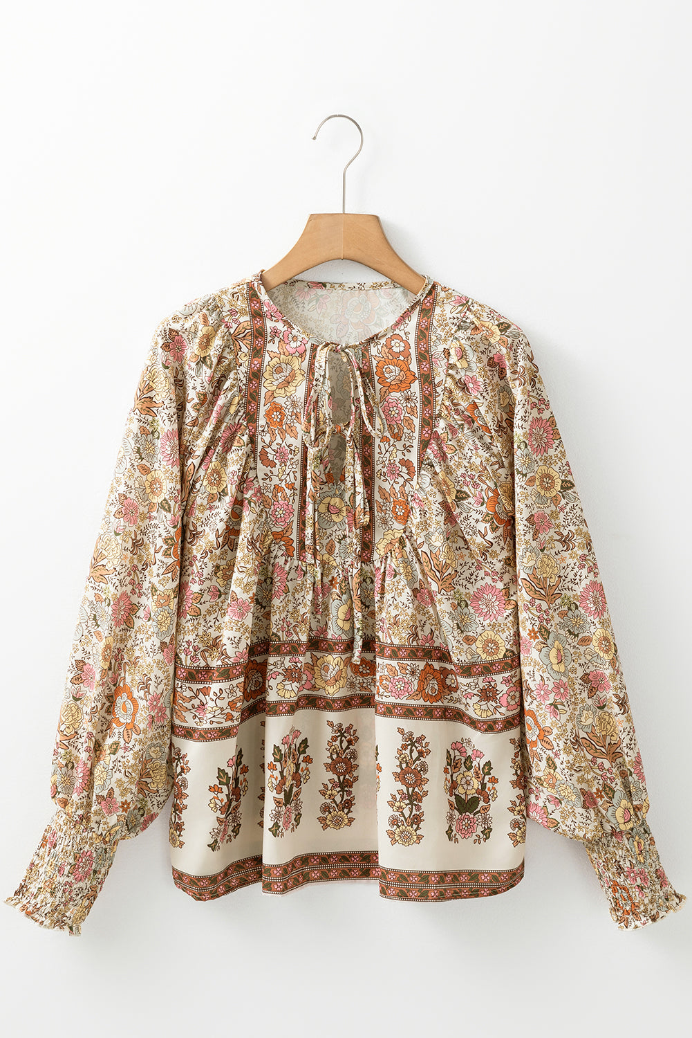 Blusa amarilla con estampado floral, cuello anudado y mangas farol