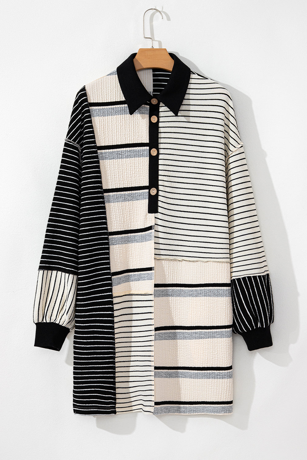 Minivestido de corte recto y manga larga con diseño de bloques de color y rayas negras, cuello Henley y tejido de punto.