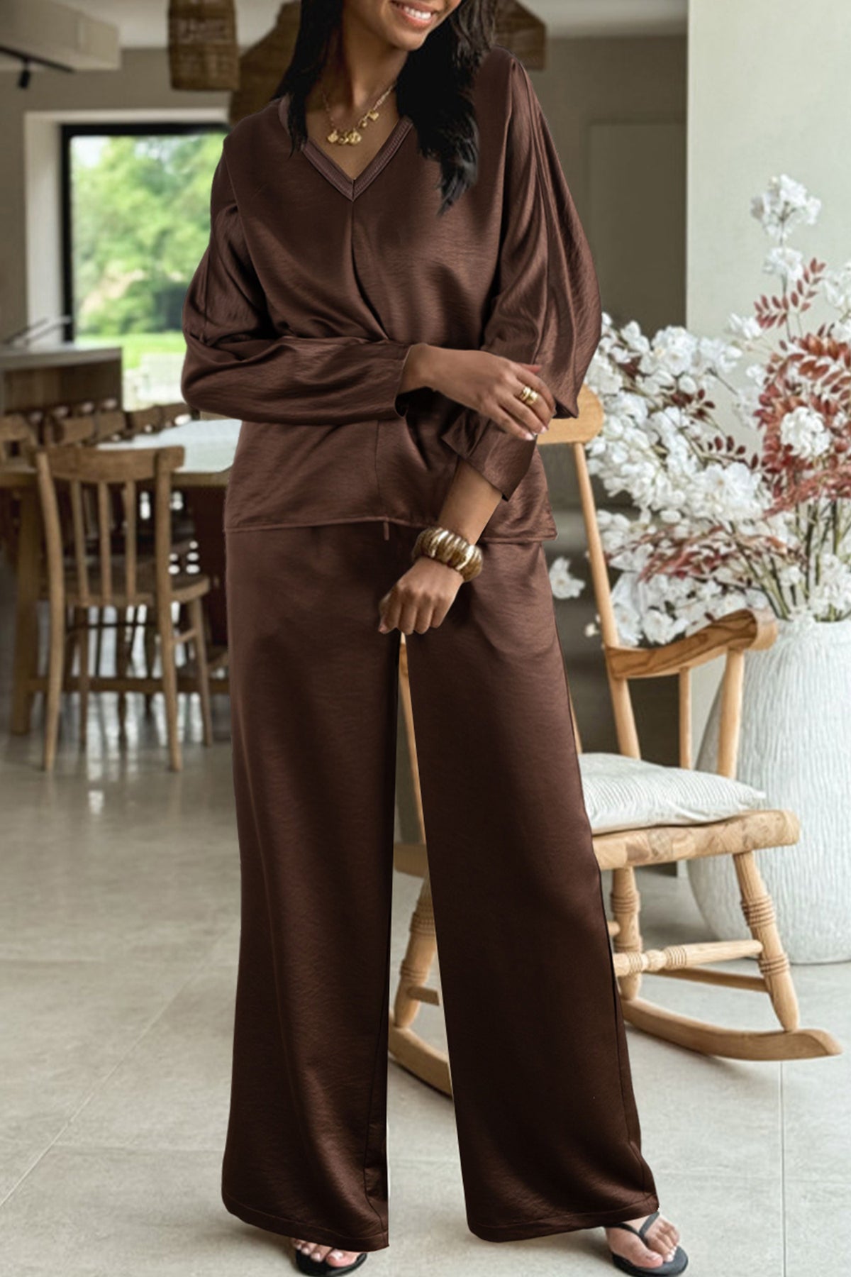 Conjunto de 2 piezas: blusa holgada de manga larga con cuello en V y detalle trenzado, y pantalón de tiro alto con cordón, en color marrón oscuro.
