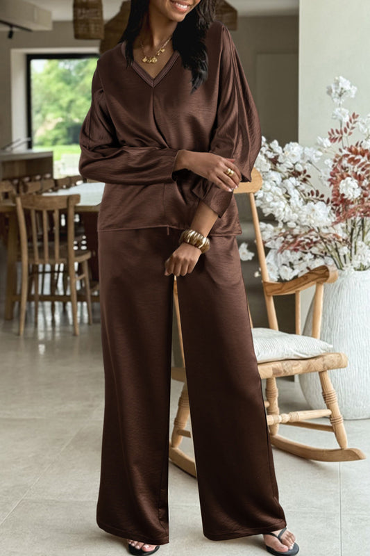 Conjunto de 2 piezas: blusa holgada de manga larga con cuello en V y detalle trenzado, y pantalón de tiro alto con cordón, en color marrón oscuro.