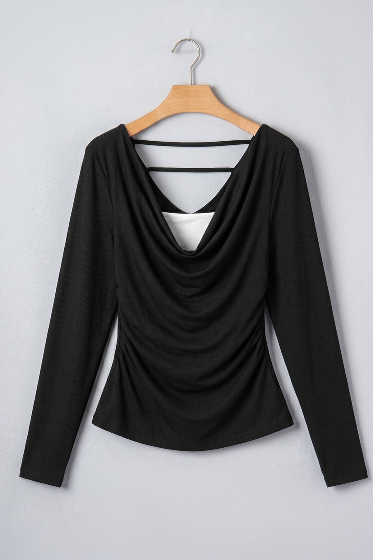 Top negro con cuello en V y mangas largas plisadas.