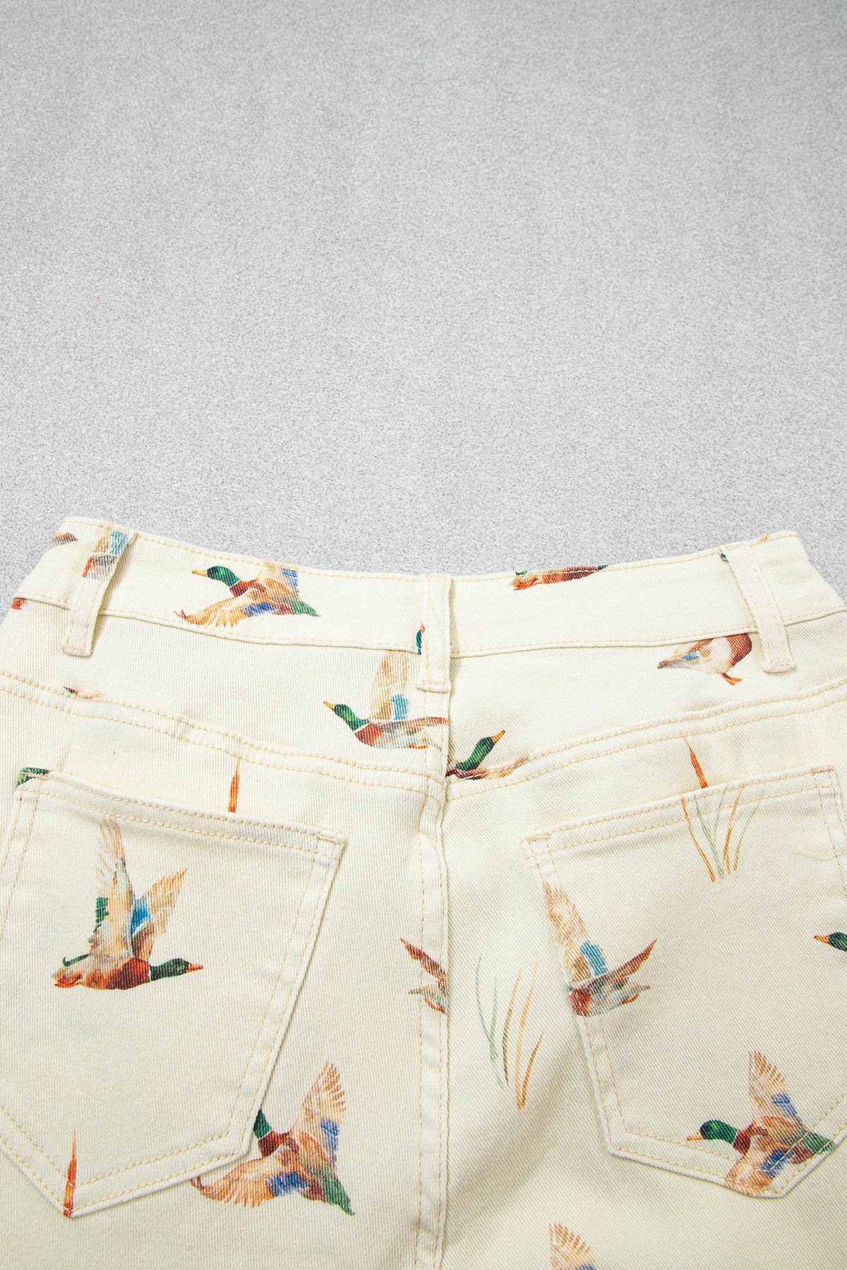 Vaqueros beige elegantes con estampado de patos y bajo con puños