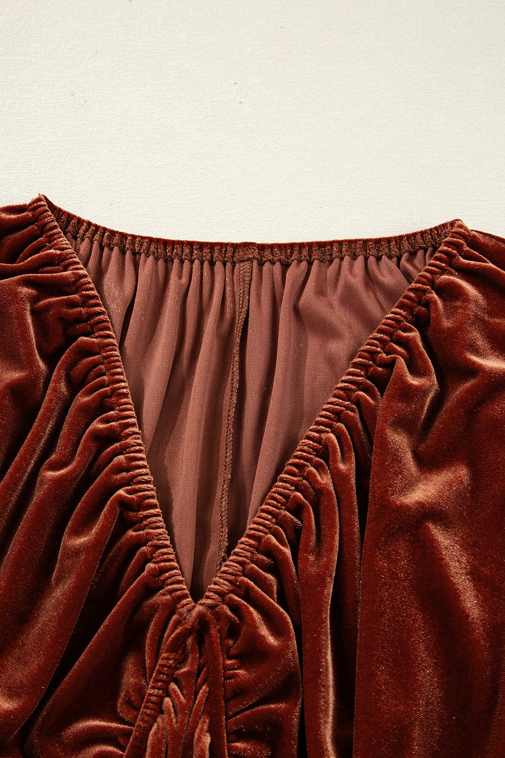 Vestido corto de terciopelo color arcilla con cuello en V, mangas abullonadas y diseño elástico.