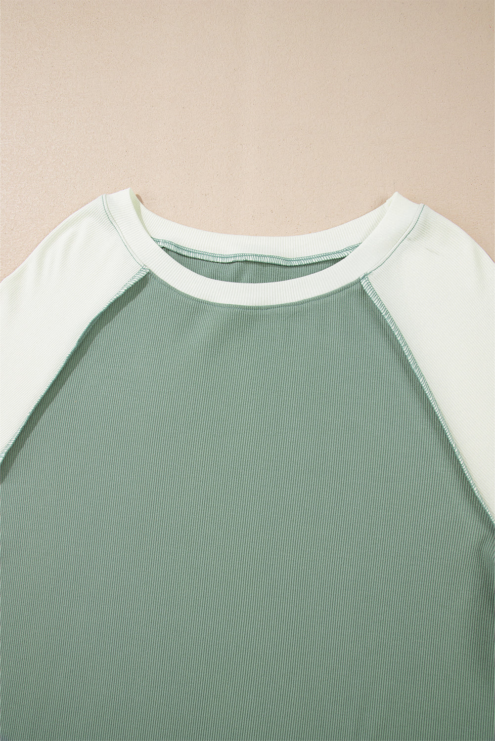 Top de manga larga raglán con diseño de bloques de color, estilo patchwork y textura acanalada, en verde menta.