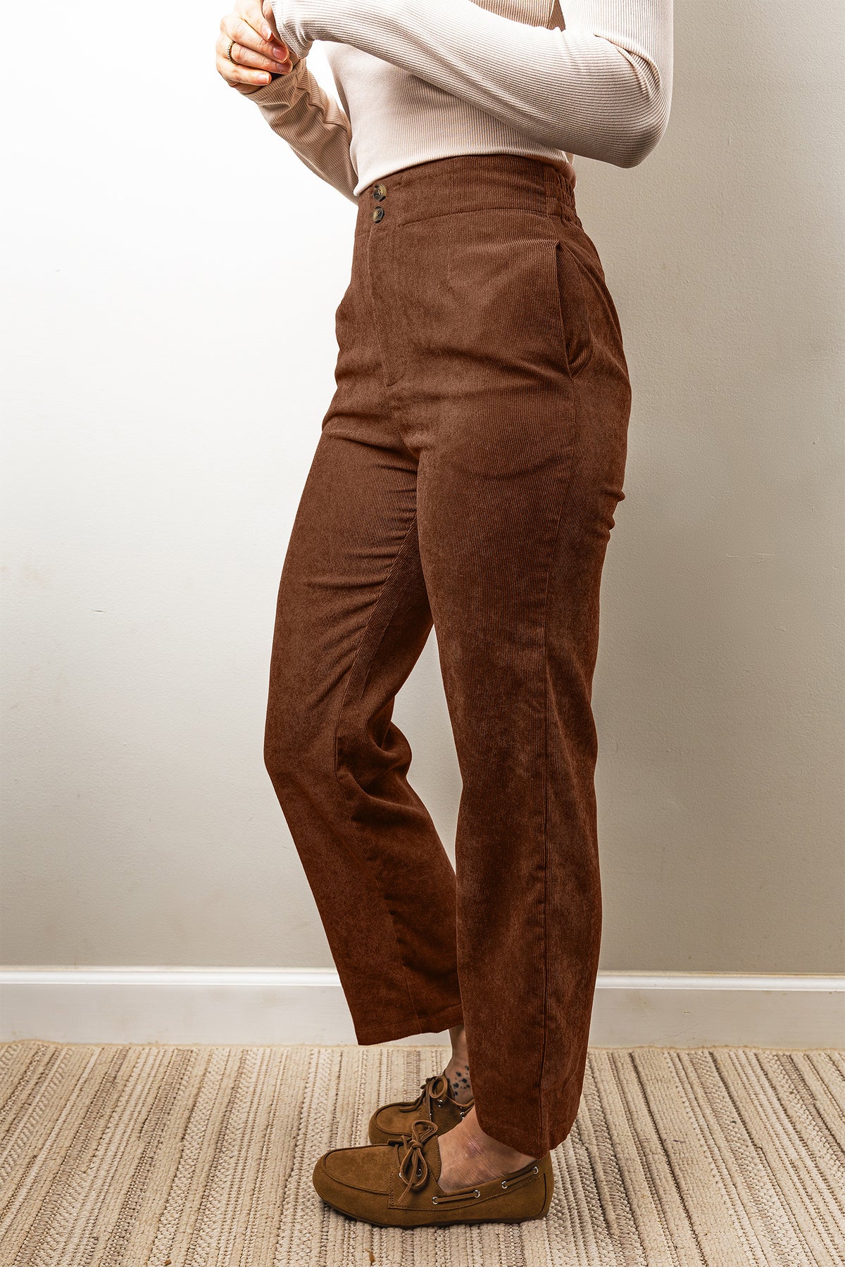 Pantalones de pana color café, de corte recto, largo al tobillo y cintura elástica.