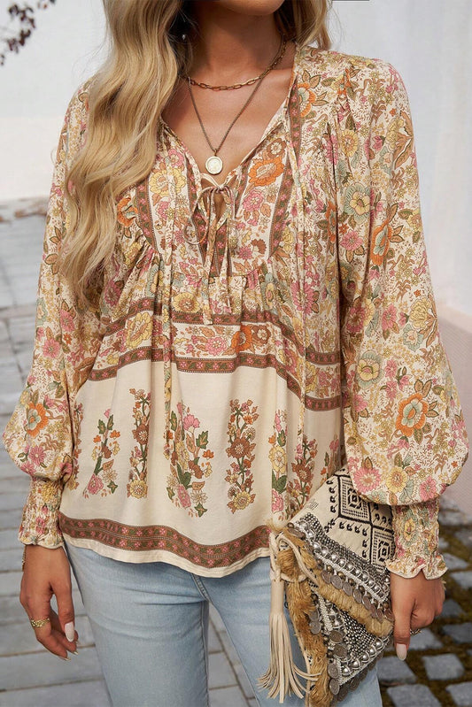 Blusa amarilla con estampado floral, cuello anudado y mangas farol