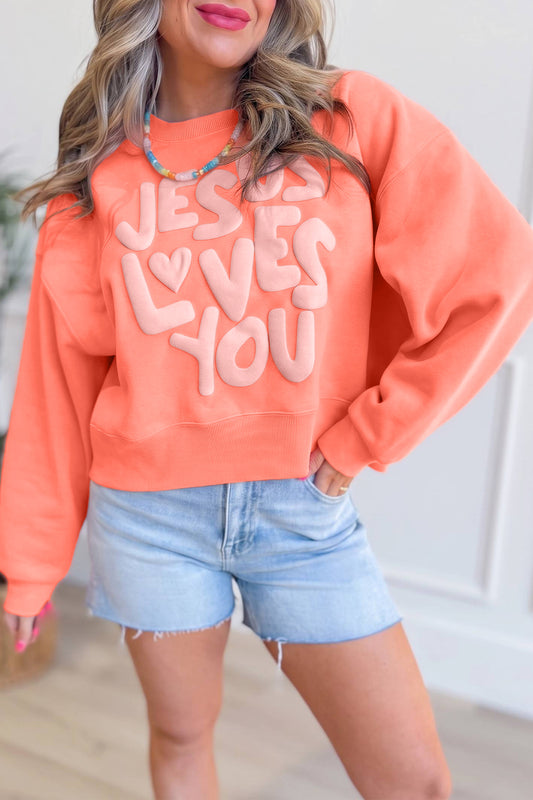 Sudadera con gráfico de letras en relieve "Jesus Loves You" (Jesús te ama) en tonos naranja y pomelo