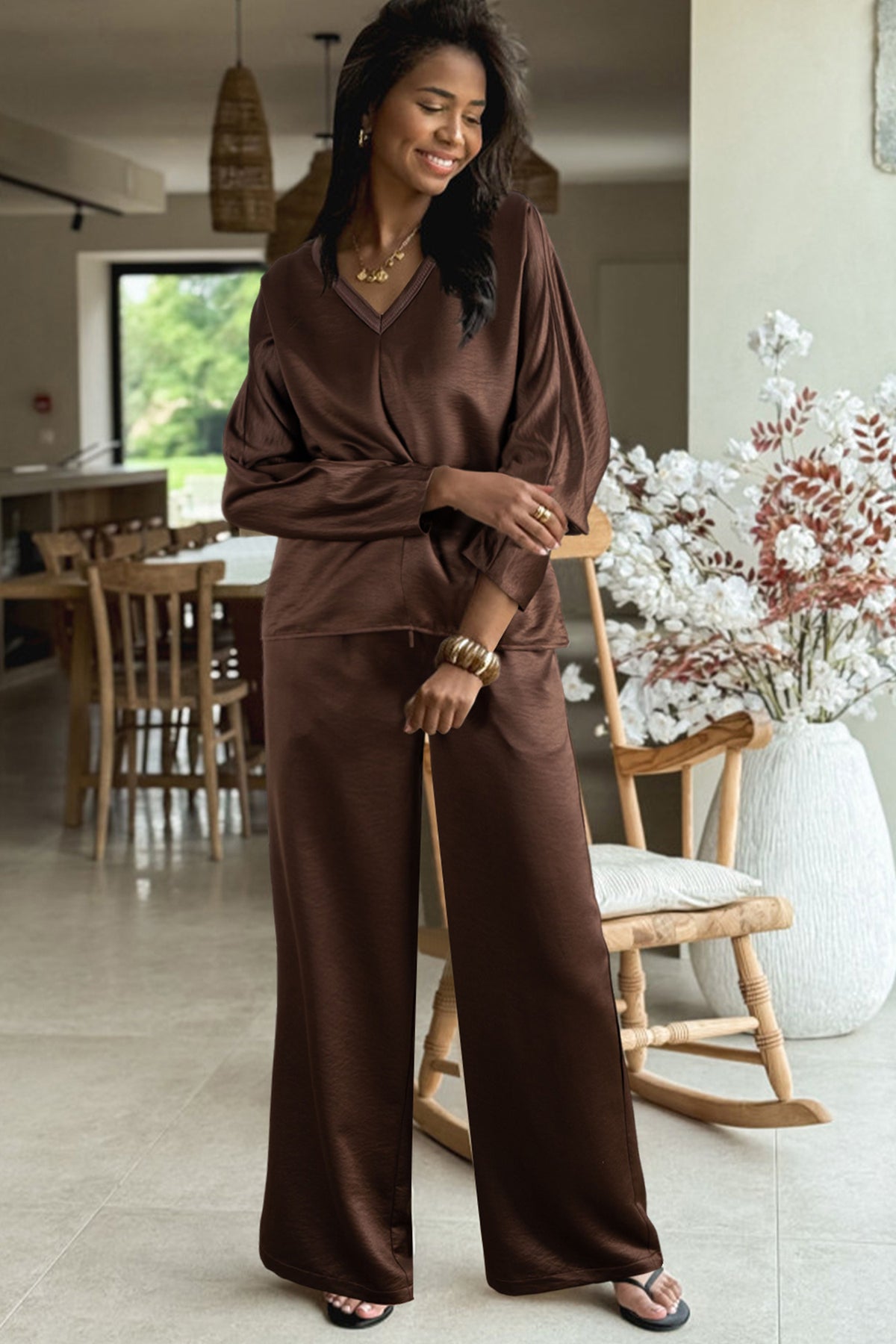Conjunto de 2 piezas: blusa holgada de manga larga con cuello en V y detalle trenzado, y pantalón de tiro alto con cordón, en color marrón oscuro.