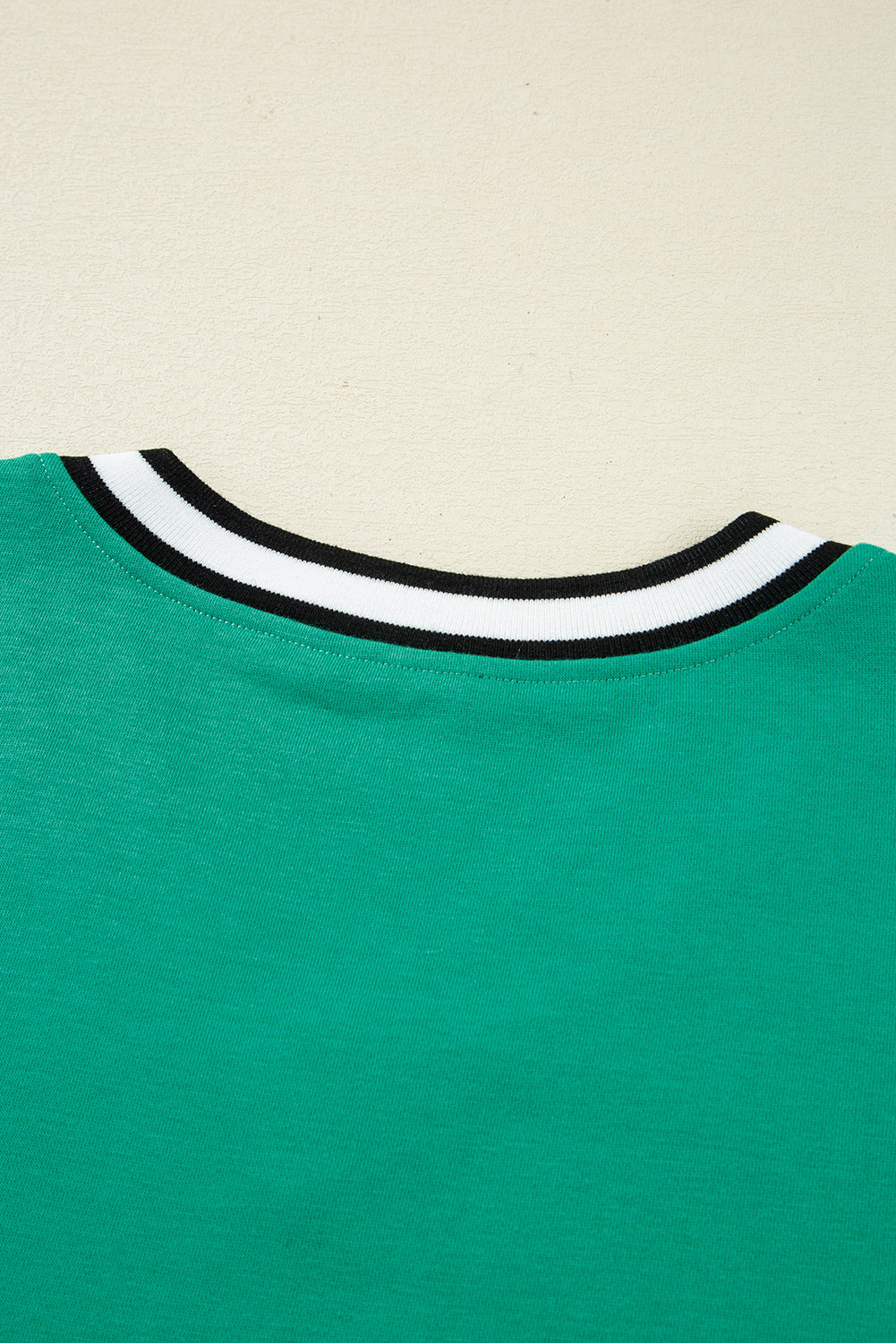 Vestido tipo camiseta de manga larga y cuello en V, color verde menta, estilo universitario con rayas en contraste y bolsillos.