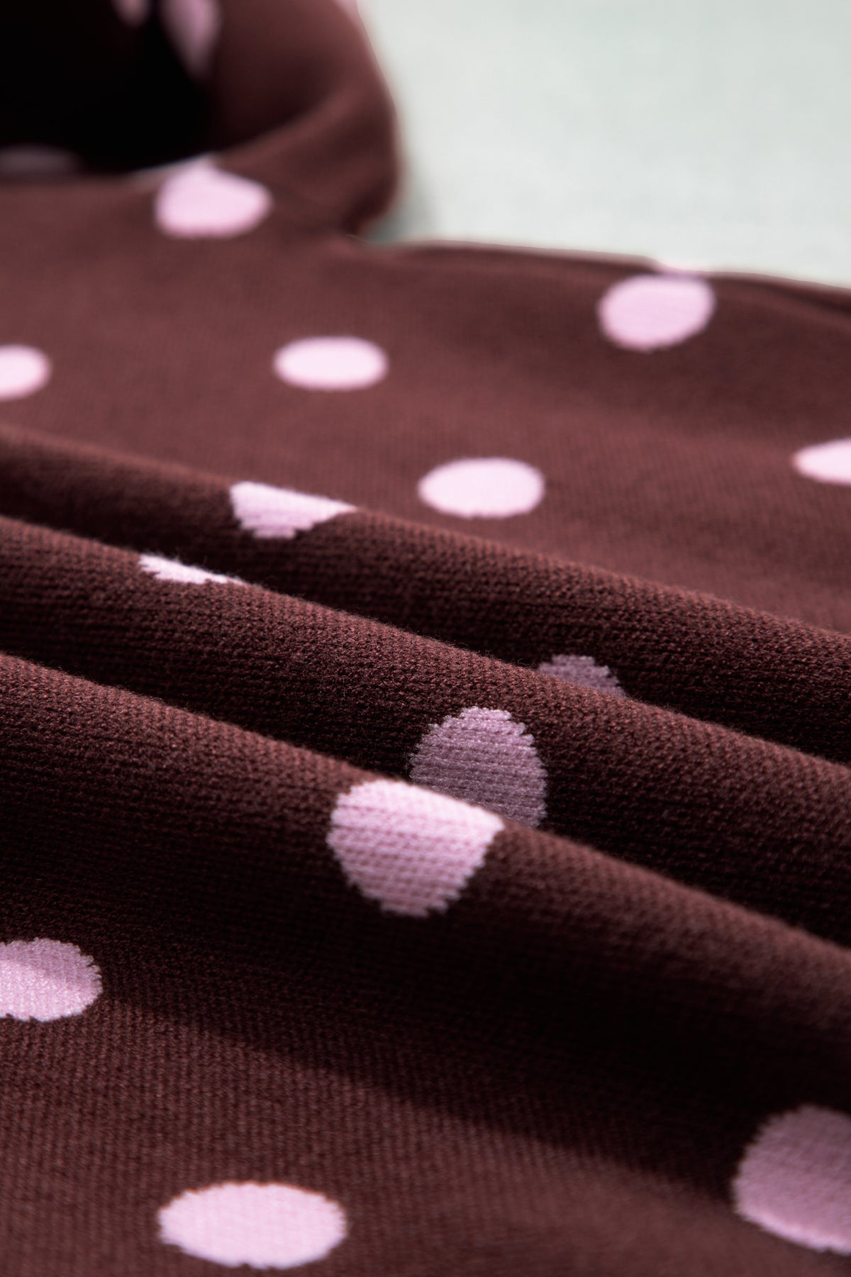 Suéter tipo pulóver holgado con cuello, diseño de bloques de color y estampado de lunares rosas.