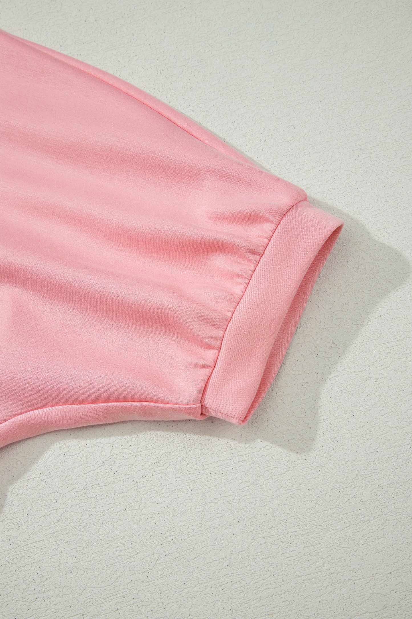 Conjunto de top tipo dolman oversize rosa con cuello en V festoneado y cordón ajustable
