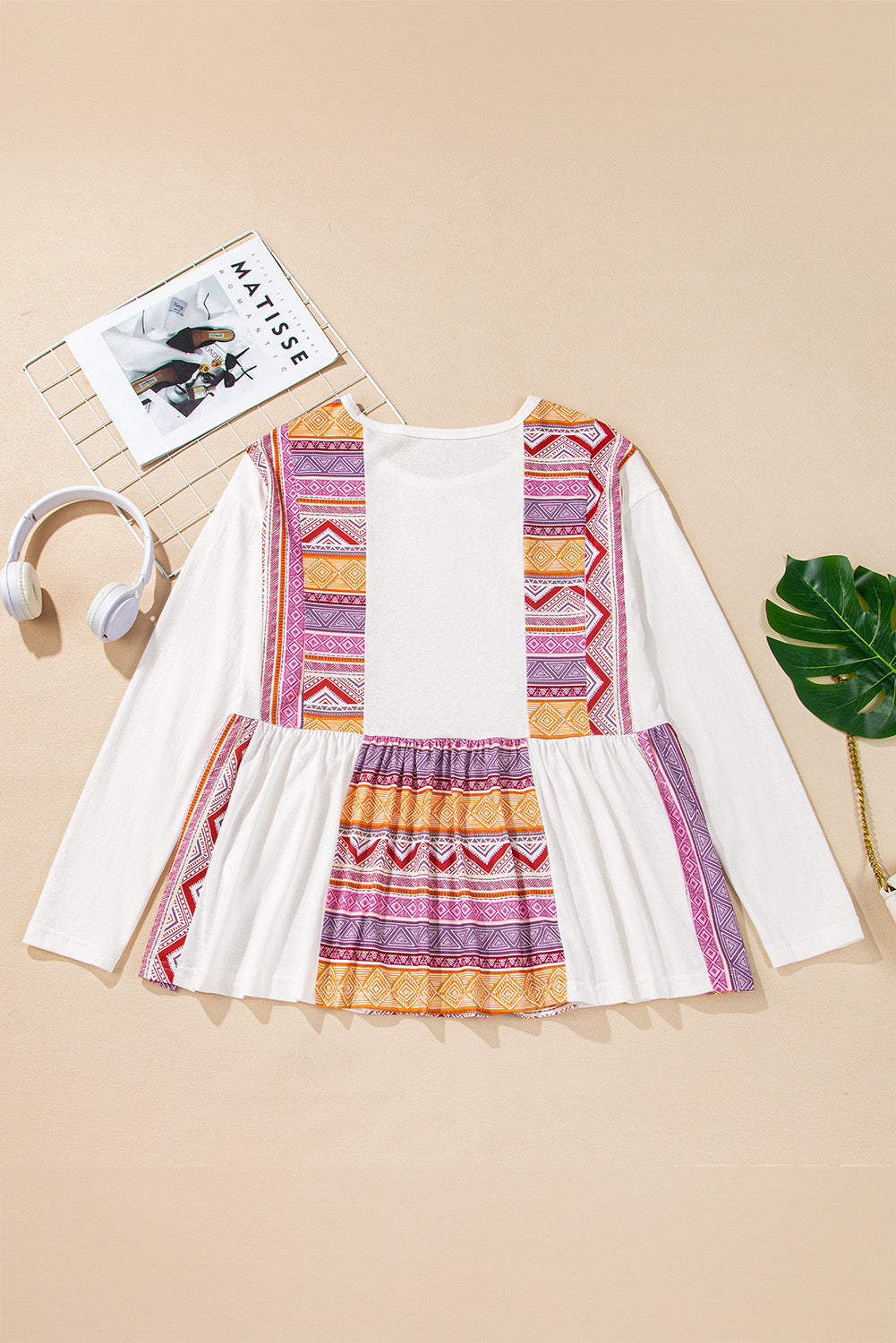 Blusa tipo túnica blanca de manga larga, corte babydoll y estilo occidental, con diseño de retazos (patchwork), estampado azteca y volantes.