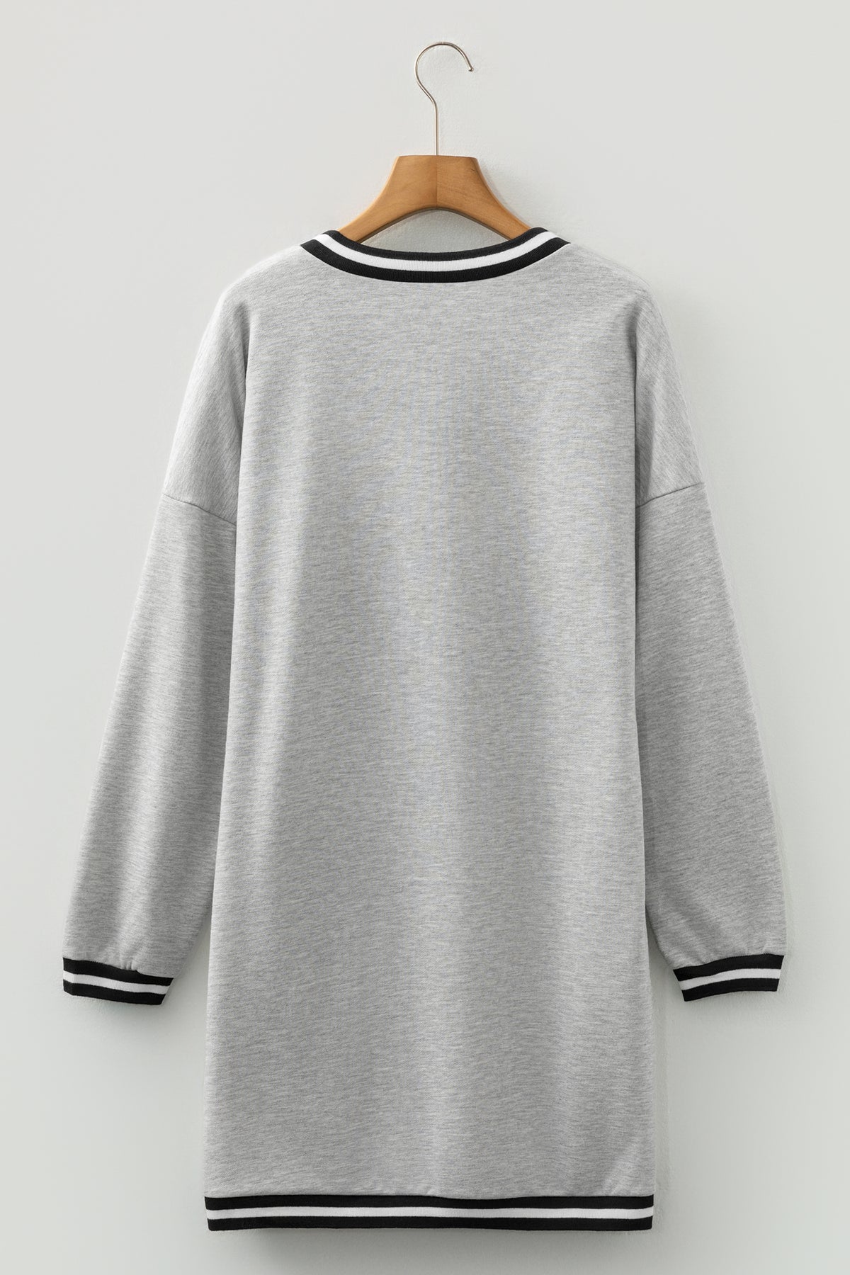 Vestido tipo camiseta de estilo preppy, manga larga y cuello en V, en gris claro con ribetes a rayas.