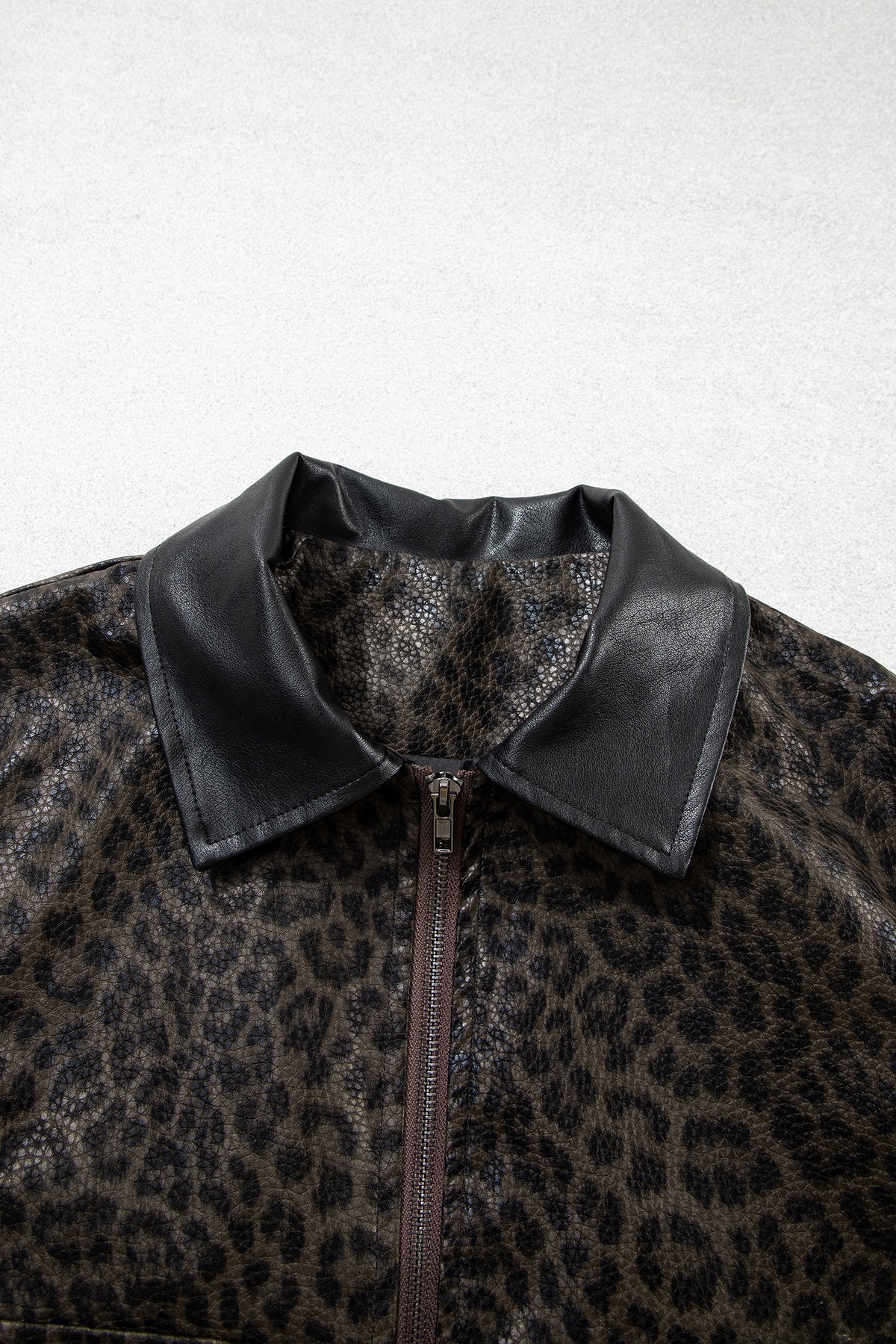 Chaqueta multicolor con estampado de leopardo, diseño en bloques de color, cuello y cierre frontal metálico.