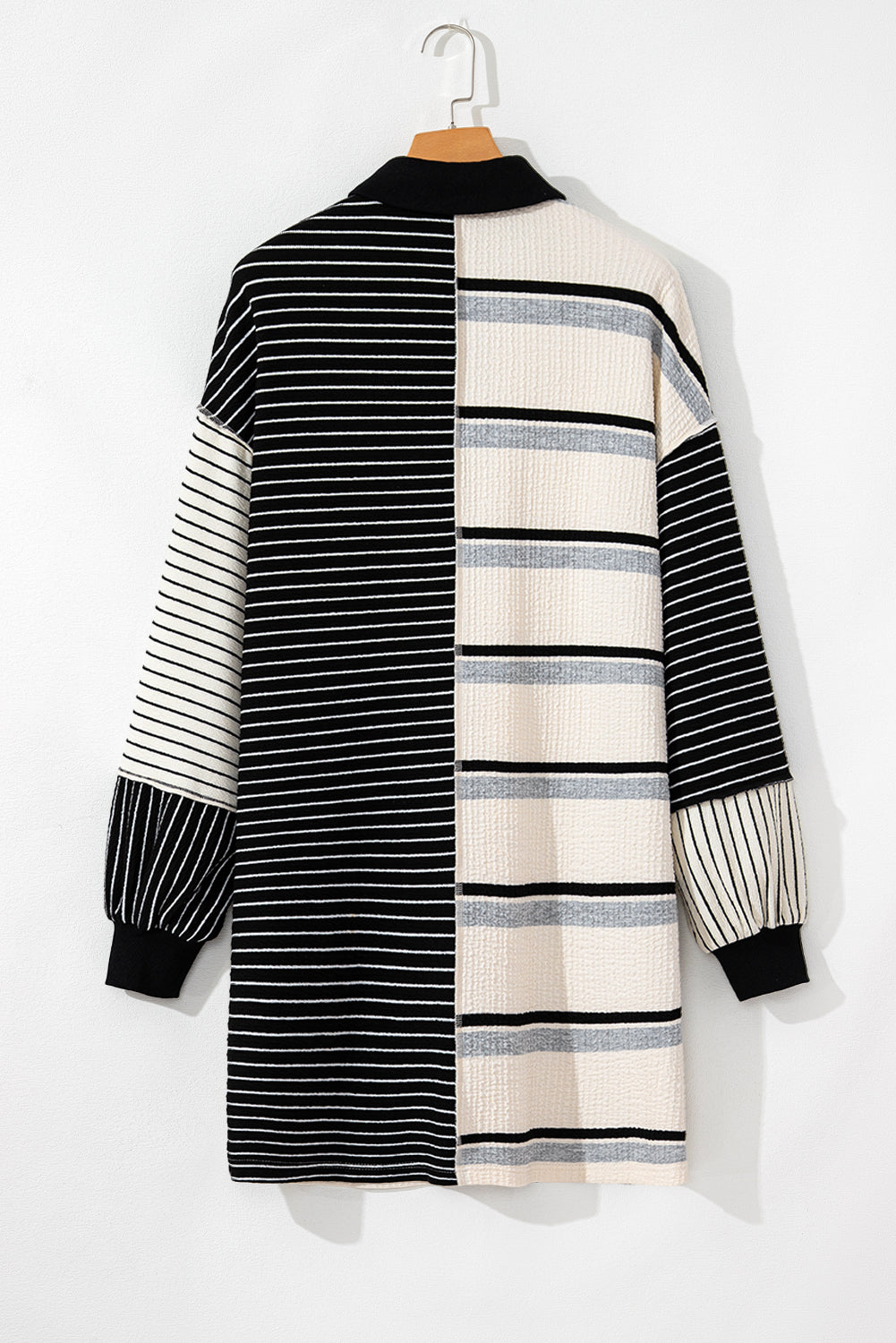 Minivestido de corte recto y manga larga con diseño de bloques de color y rayas negras, cuello Henley y tejido de punto.
