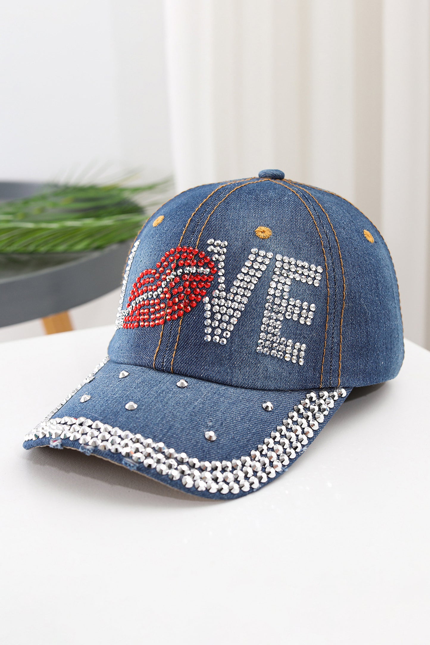 Gorra de béisbol de mezclilla Ashleigh con diseño de labios y la palabra "LOVE" adornada con pedrería azul