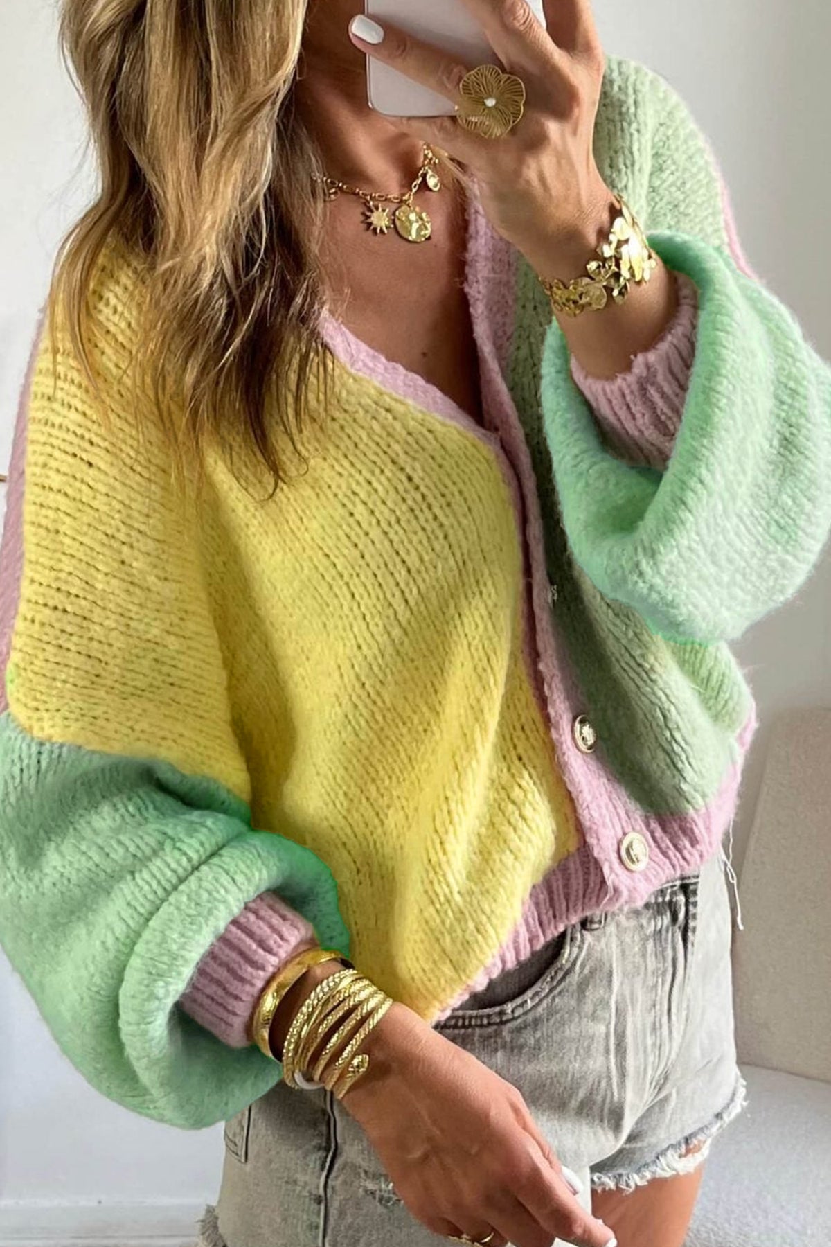Cárdigan de punto amarillo con cuello en V, hombros caídos, diseño de paneles y lavado estándar.