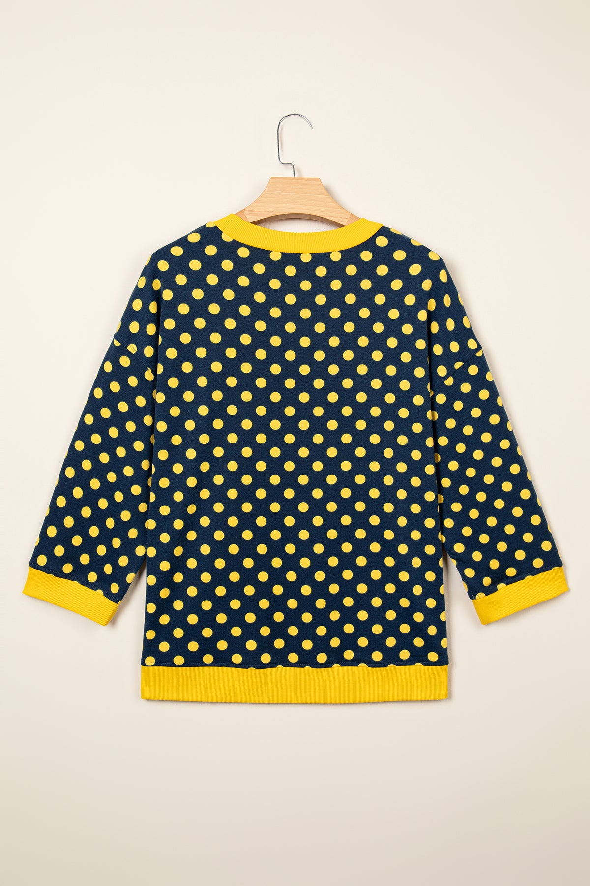 Top de cuello redondo con mangas tres cuartos, estampado de lunares marrones y ribete en contraste.