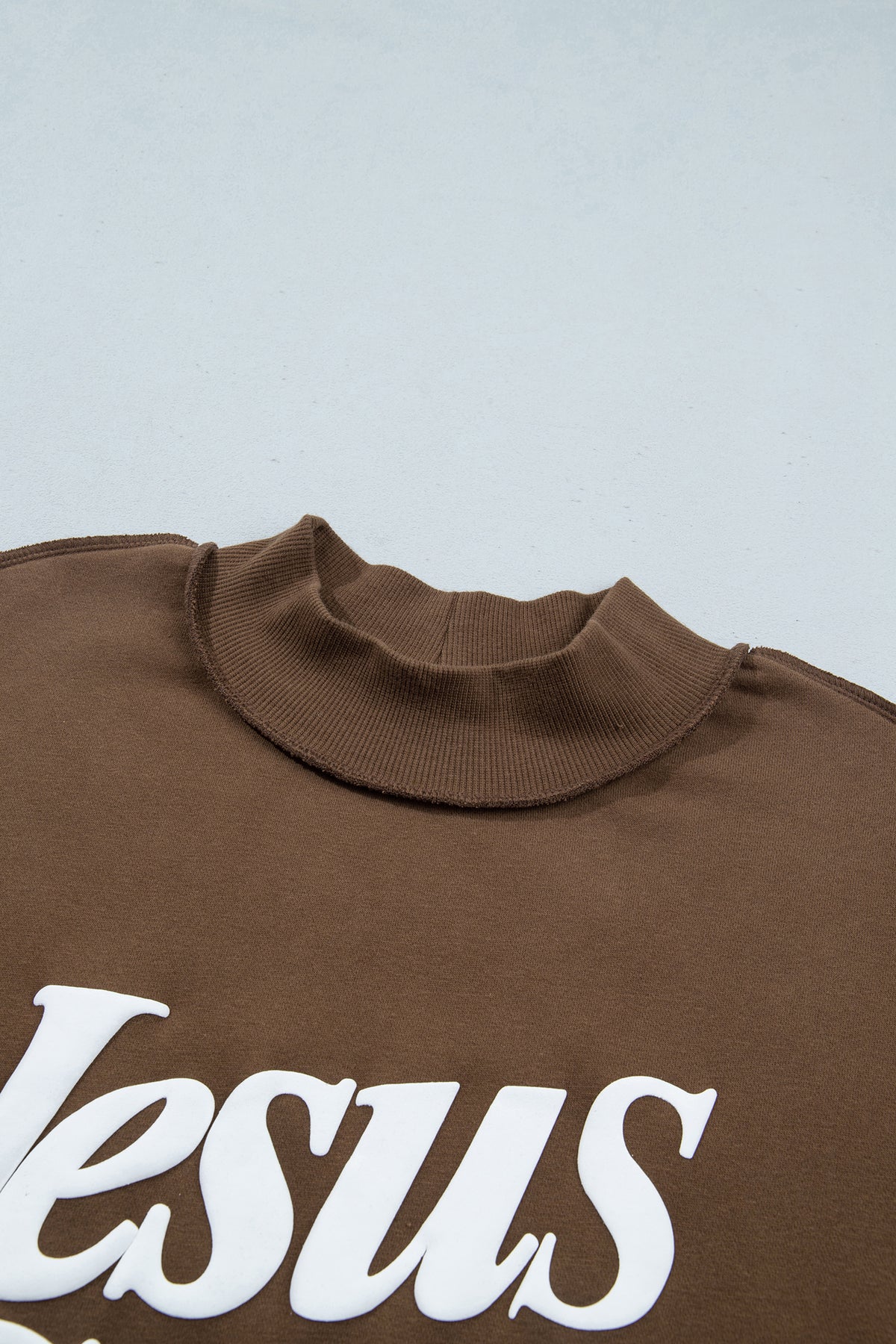 Sudadera holgada de color marrón oscuro con cuello alzado y estampado del eslogan «Jesus Saves»
