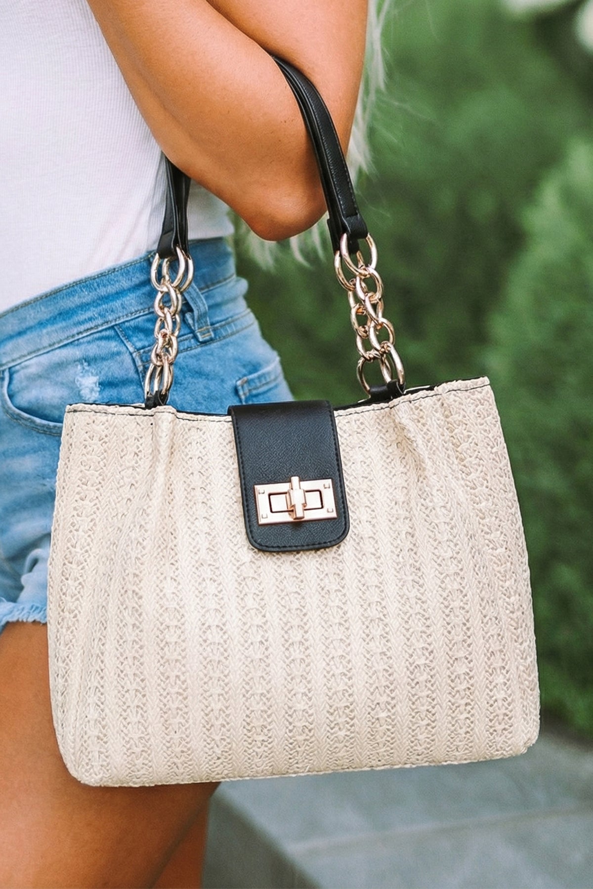 Bolso tote negro de piel sintética con textura tejida y asa de cadena