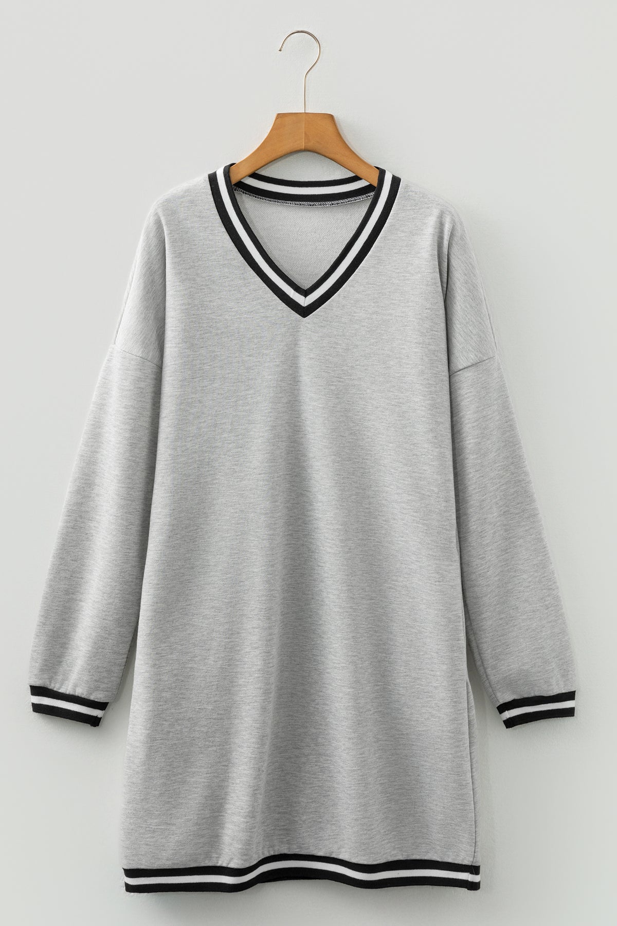 Vestido tipo camiseta de estilo preppy, manga larga y cuello en V, en gris claro con ribetes a rayas.