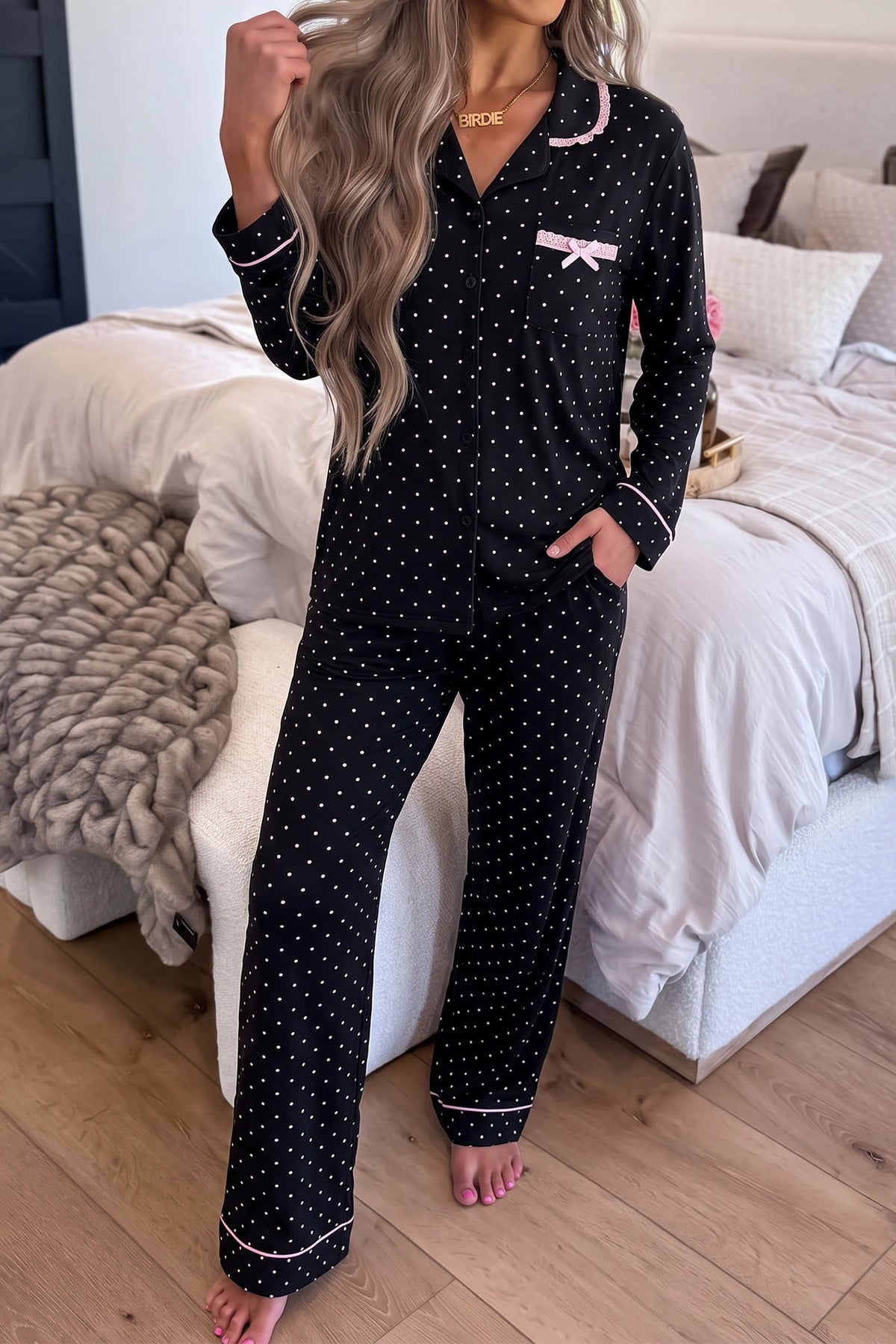 Conjunto de pijama de dos piezas: camisa de manga larga negra con lunares y detalles de encaje, y pantalón.