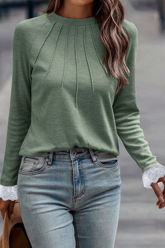 Top de manga raglán con detalle de costura en verde hierba, puños de encaje en contraste y mangas raglán.