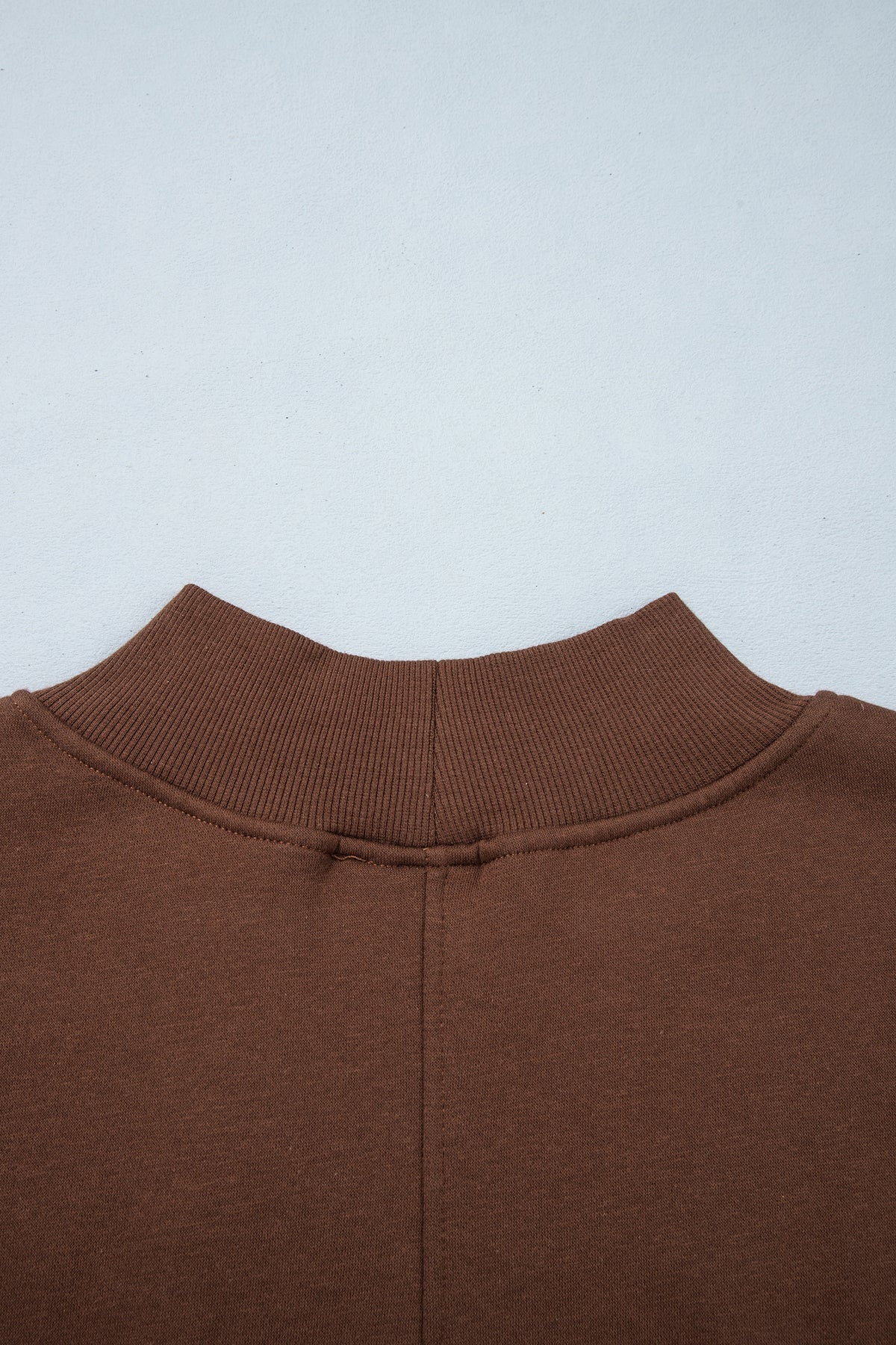 Sudadera tipo túnica de color liso, corte oversize, cuello alto y bajo con aberturas, en color café