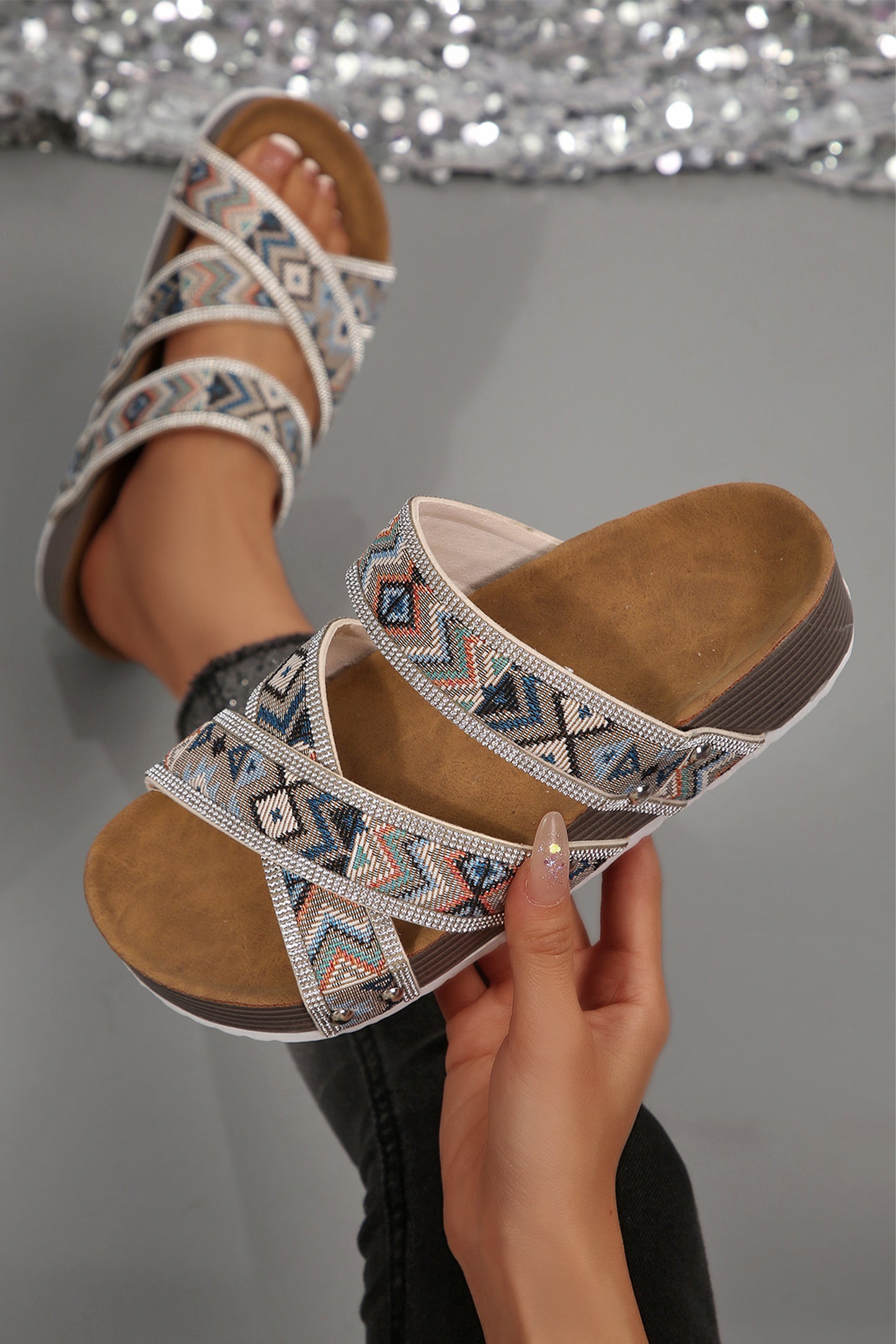 Sandalias de plataforma negras con diseño tribal geométrico, adornos de pedrería, tiras y aberturas.