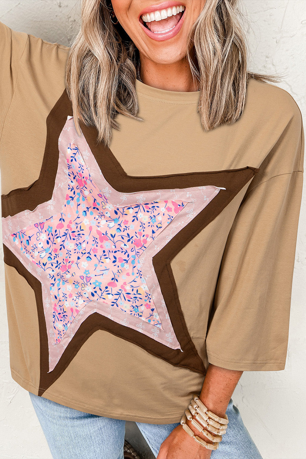 Top de manga tres cuartos con estampado floral y diseño de parches tipo estrella en color camel
