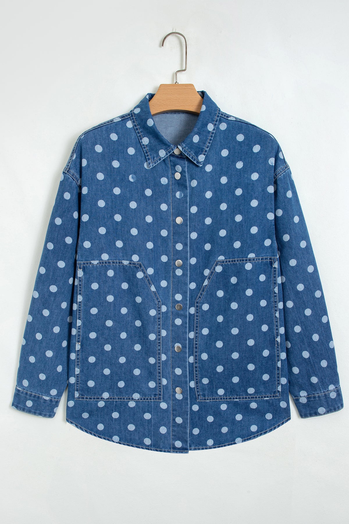 Chaqueta tipo túnica de mezclilla, corte recto, con cuello, manga larga y estampado de lunares azules.
