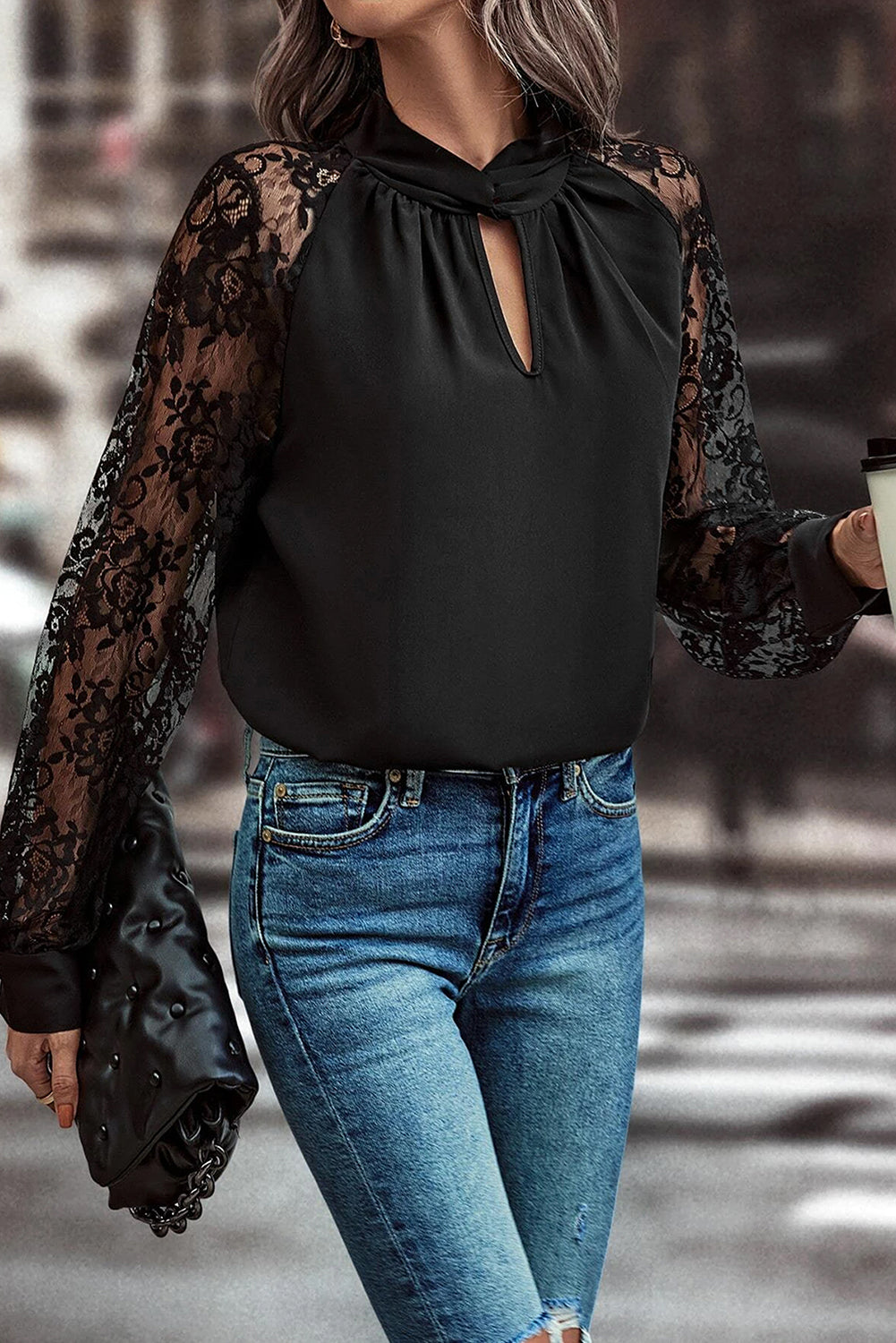 Blusa negra de encaje floral con manga raglán y abertura en el cuello
